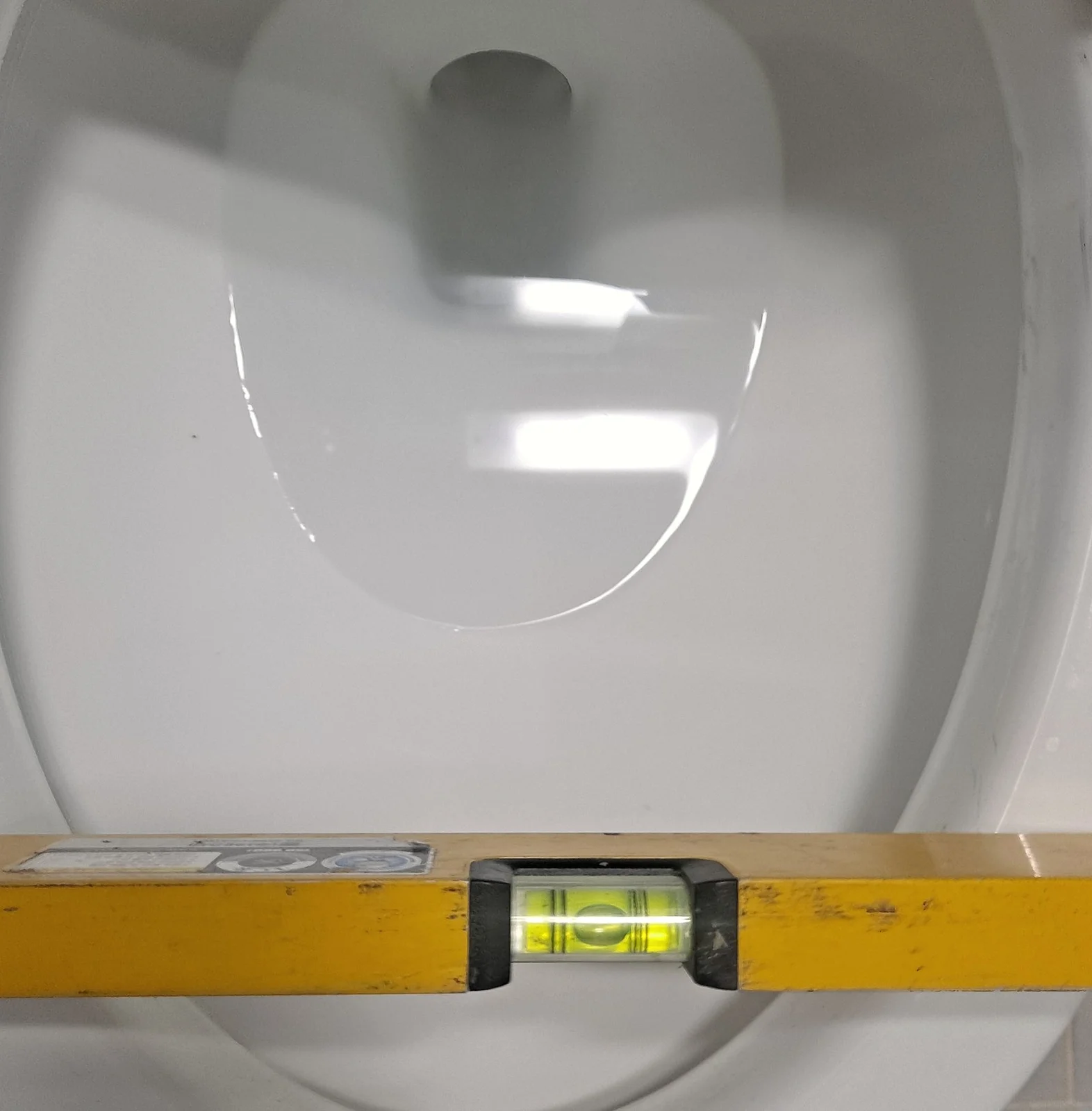 군포 변기물샘 변기수리 깨진 변기백시멘트 걷어내고 욕실실리콘으로 재시공 1명 1시간 시공 현장 사진 2 — 수평기를 올려 변기 기울기 확인